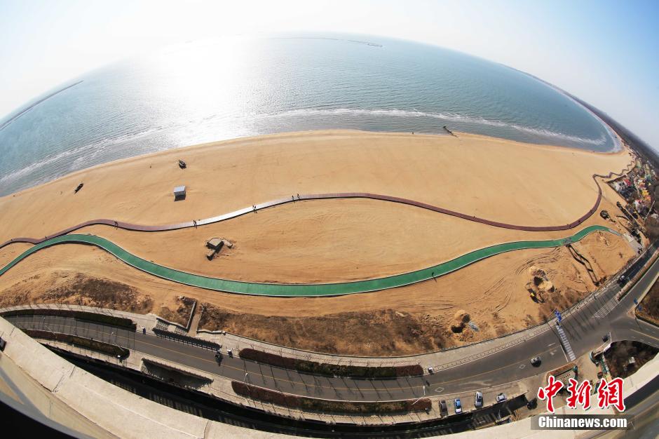3月13日，秦皇島萬米臨海沙灘木棧道。據(jù)了解，該木棧道全長約4200米，與北戴河區(qū)原有的7500米木棧道對接后全線總長度1.17萬米，整個木棧道東起秦皇島體育基地游船碼頭，西至北戴河濕地公園，呈波浪形蜿蜒10.4公里海岸線。 中新社發(fā) 曹建雄 攝 CNSPHOTO